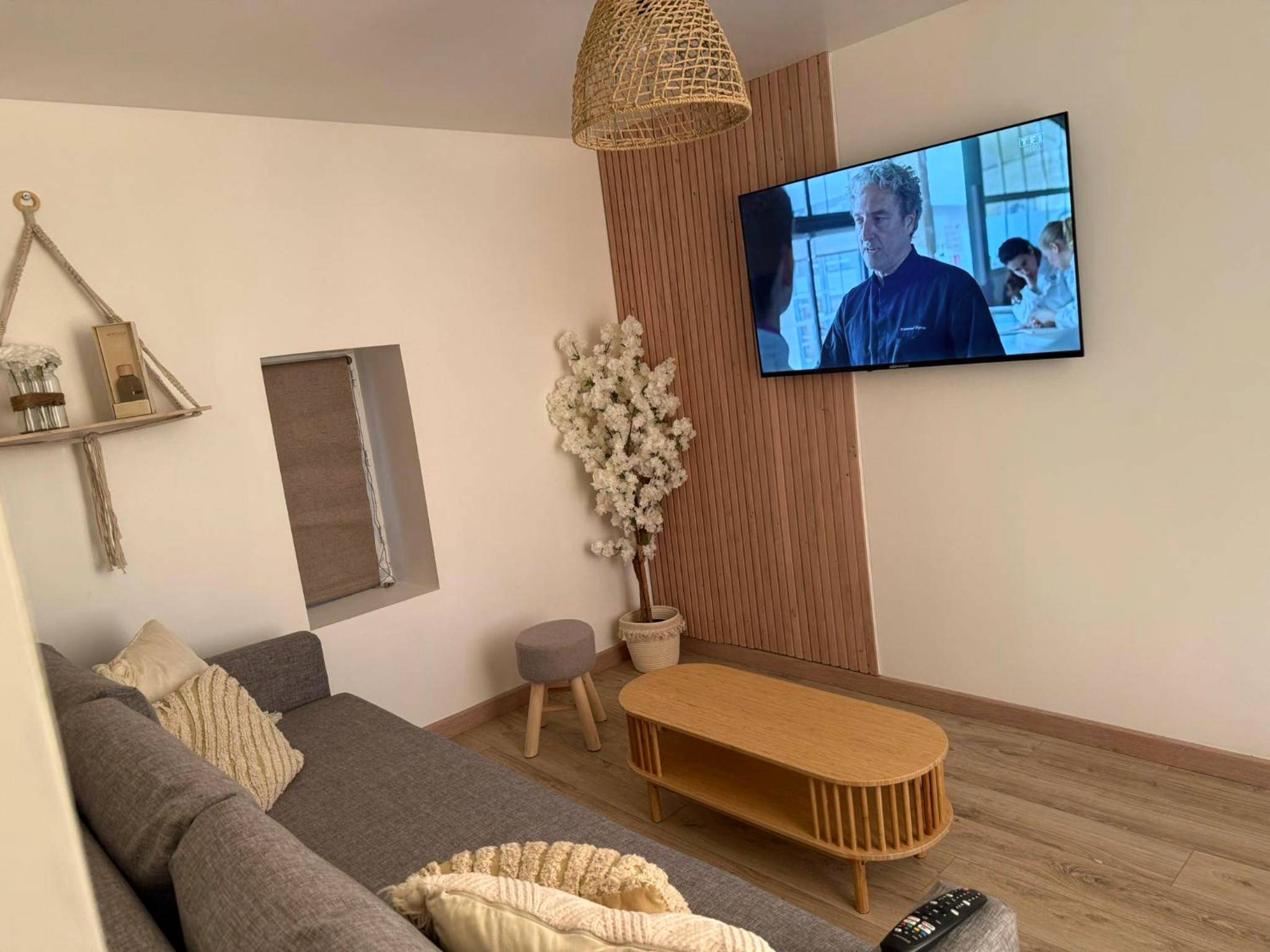 Salon avec canapé gris et télévision murale - Désirs d'une nuit - La détente