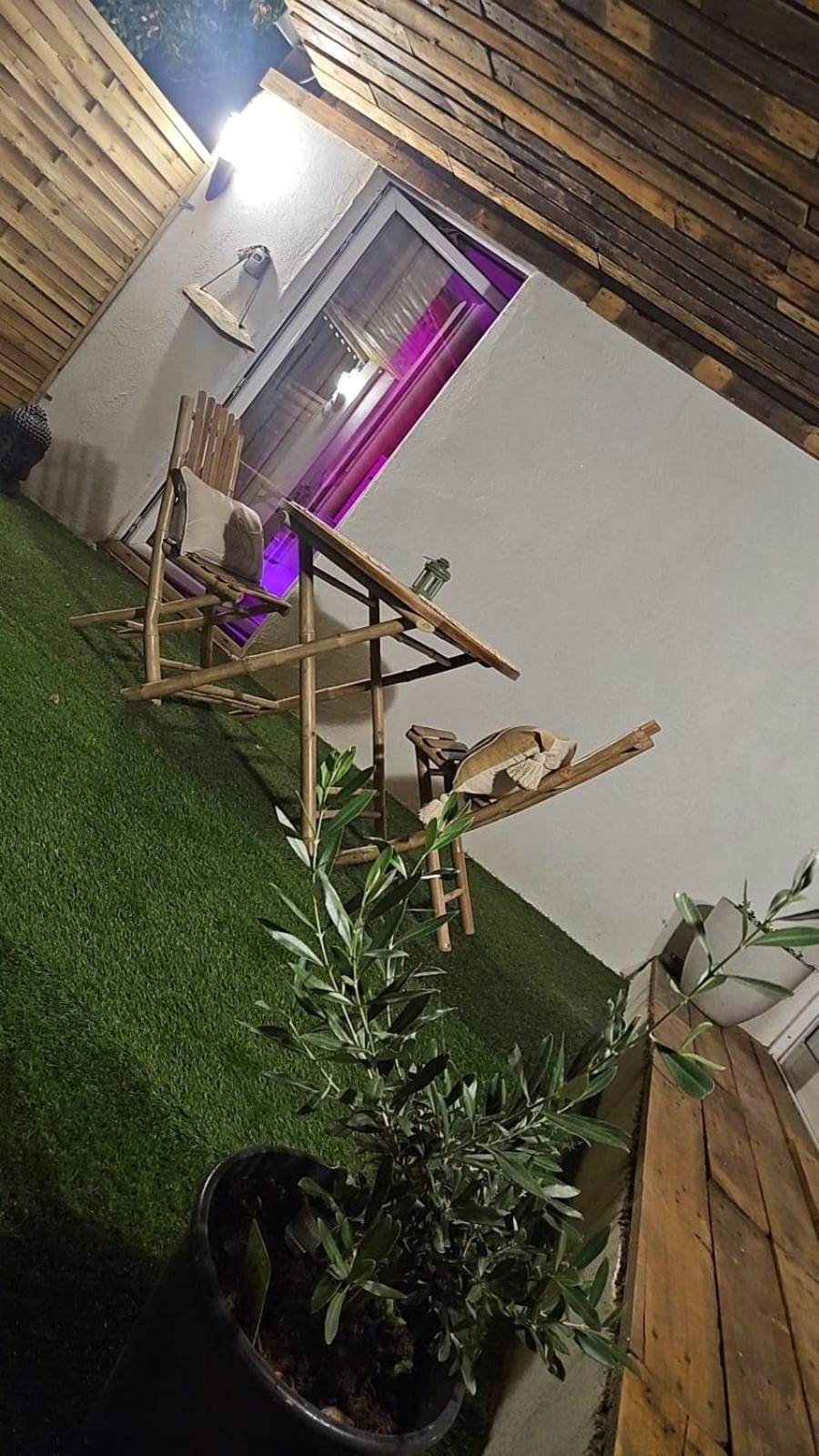 Terrasse avec mobilier en bambou et gazon - Les dessous du Garlaban