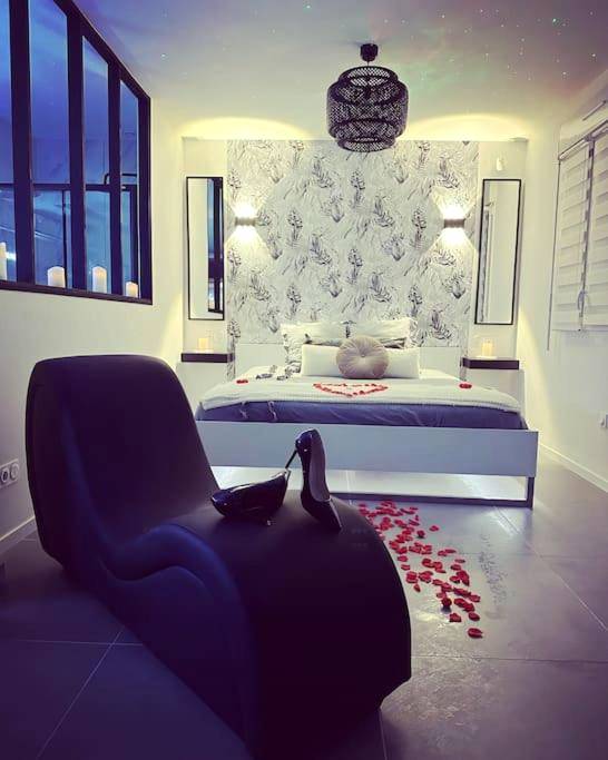 Fauteuil tantra et lit avec pétales de roses - Love Room Marzan - Le Diamant Secret Love room gîte de charme romantique...