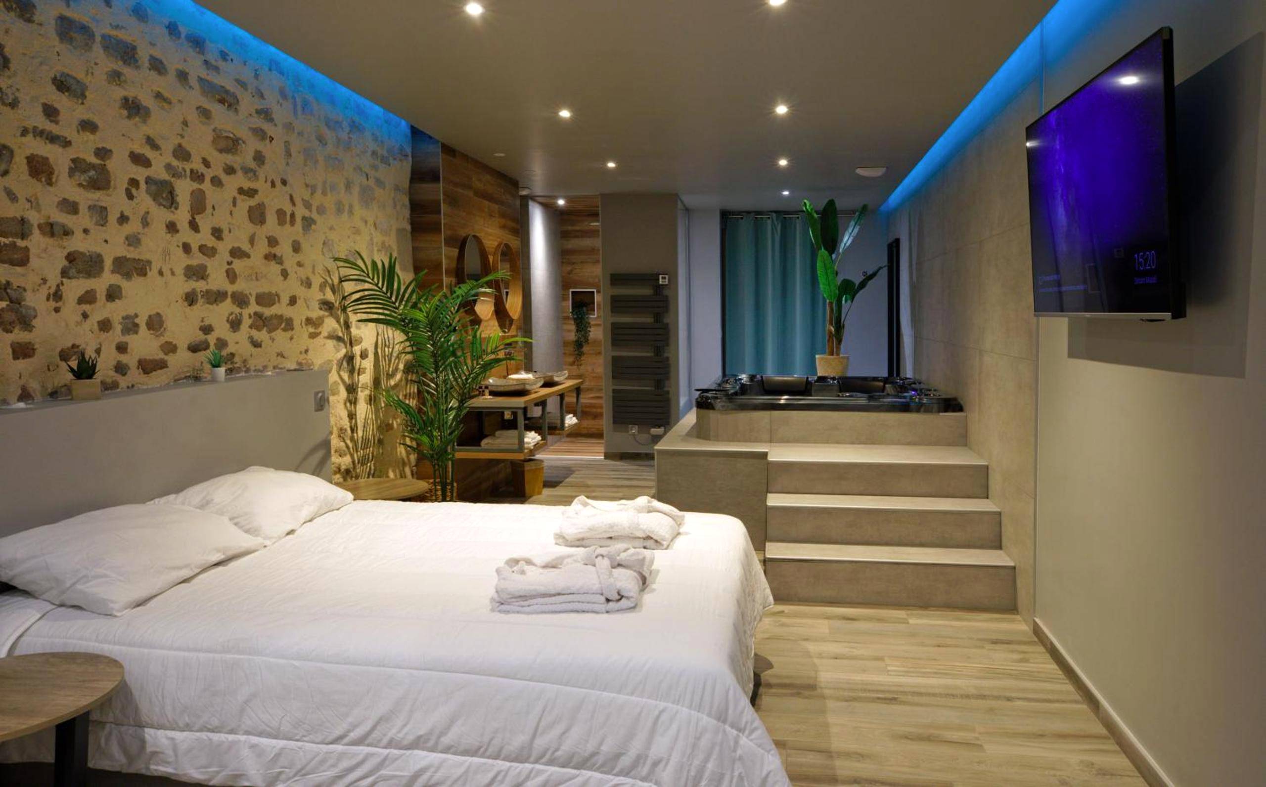 Chambre avec lit double et jacuzzi en arrière - plan - Love Room Besançon - LA DOLCEVITA SPA Suite privative