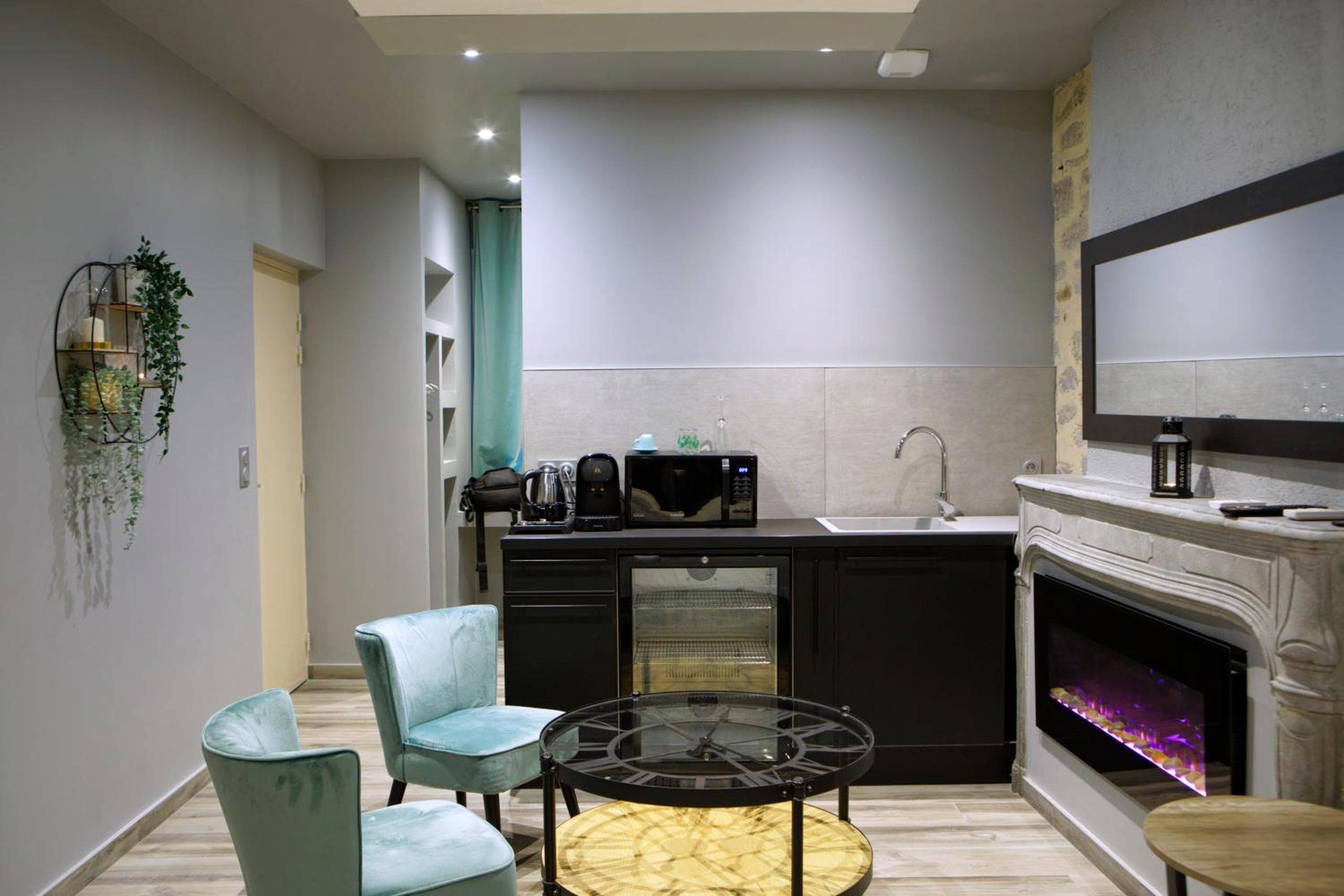 Espace salon avec cheminée et coin cuisine - LA DOLCEVITA SPA Suite privative