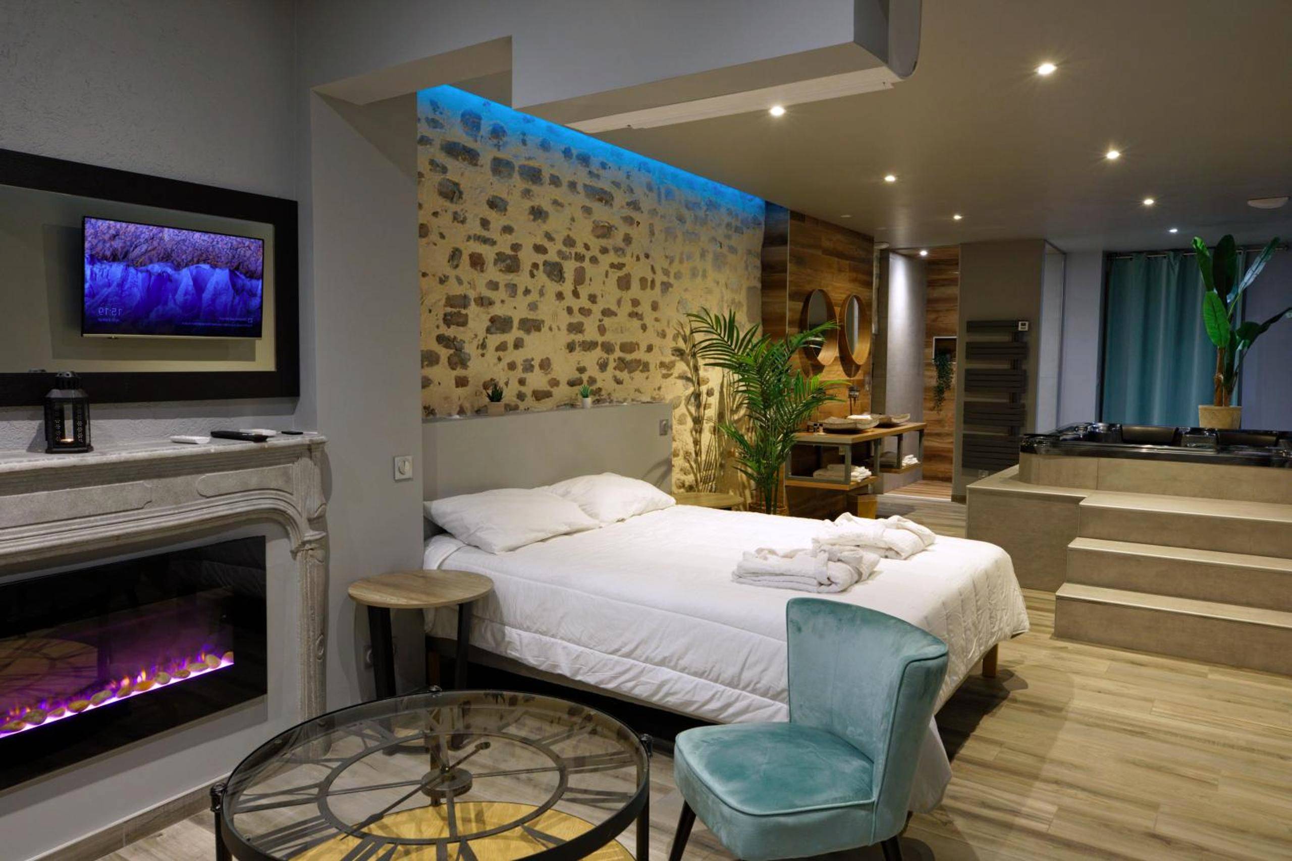 Vue d'ensemble de la suite avec cheminée et lit - LA DOLCEVITA SPA Suite privative