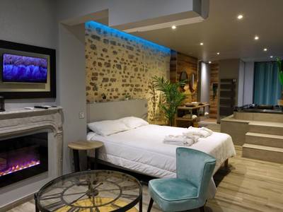 Vue d'ensemble de la suite avec cheminée et lit - LA DOLCEVITA SPA Suite privative