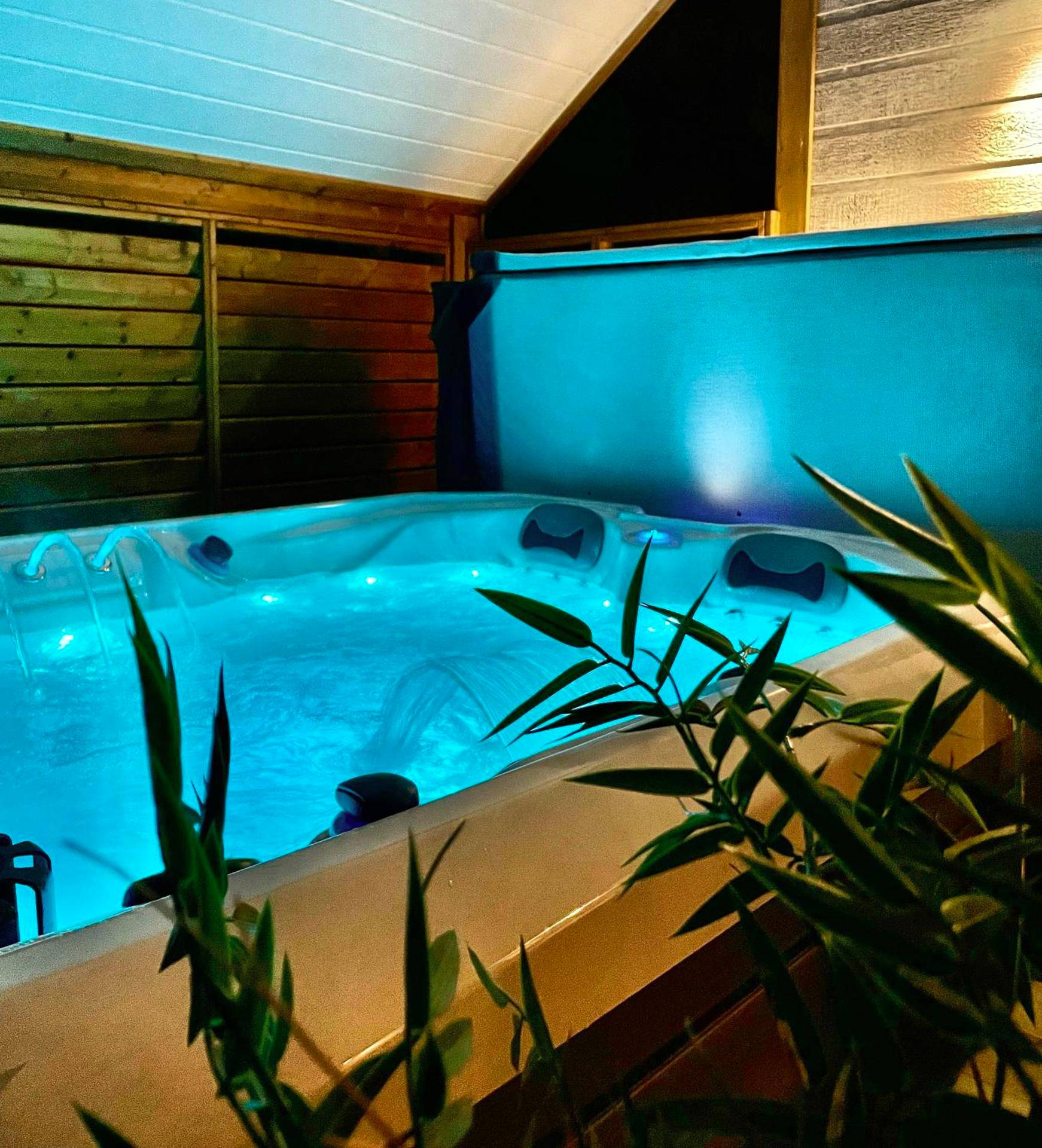 Jacuzzi privatif avec éclairage bleu tamisé - Love Room Aydat - Domaine les 2 Mondes