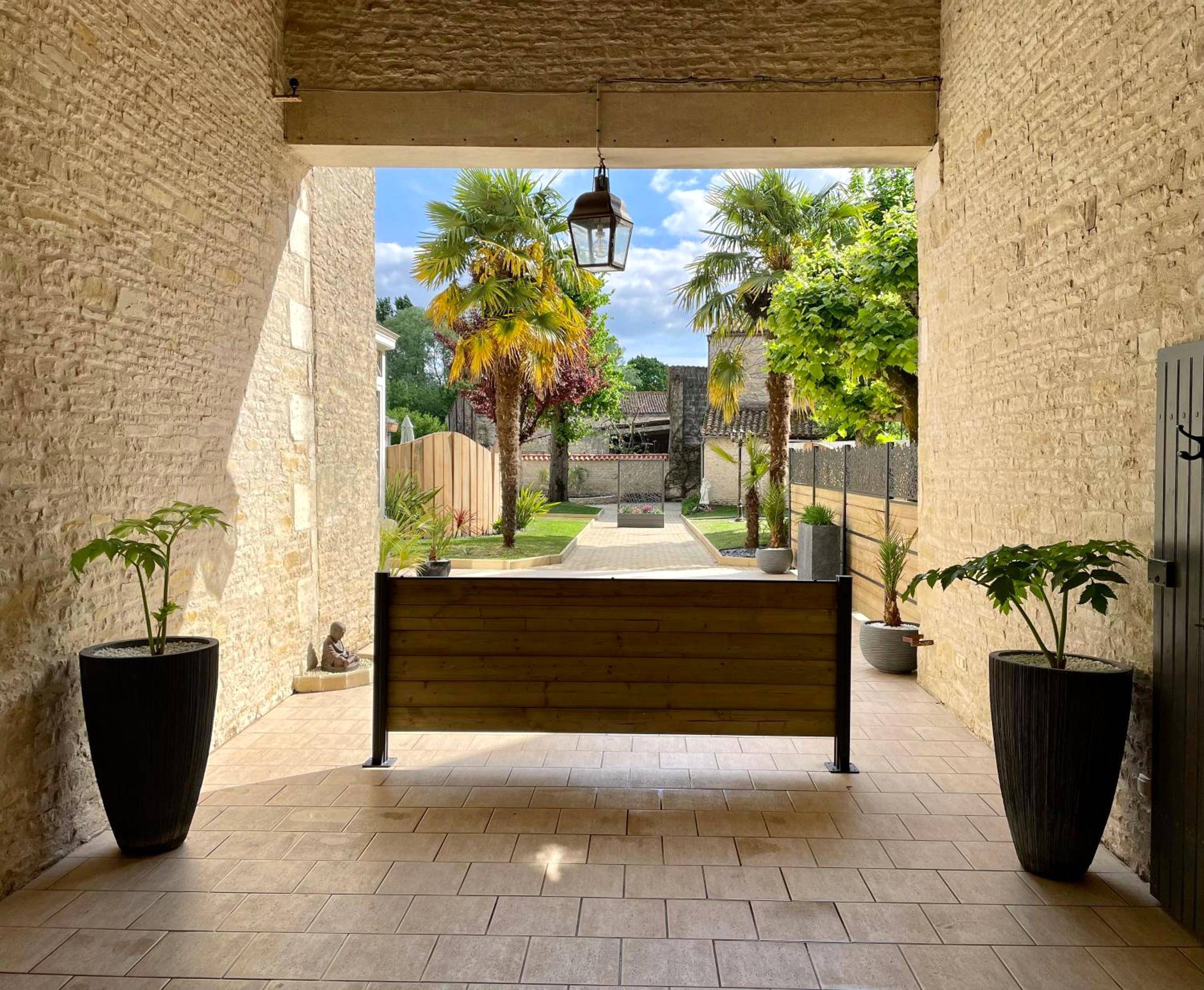 Entrée voûtée en pierre avec vue sur jardin - Love Room Arçais - Domaine de l'Angélique - Loft avec SPA privatif -...
