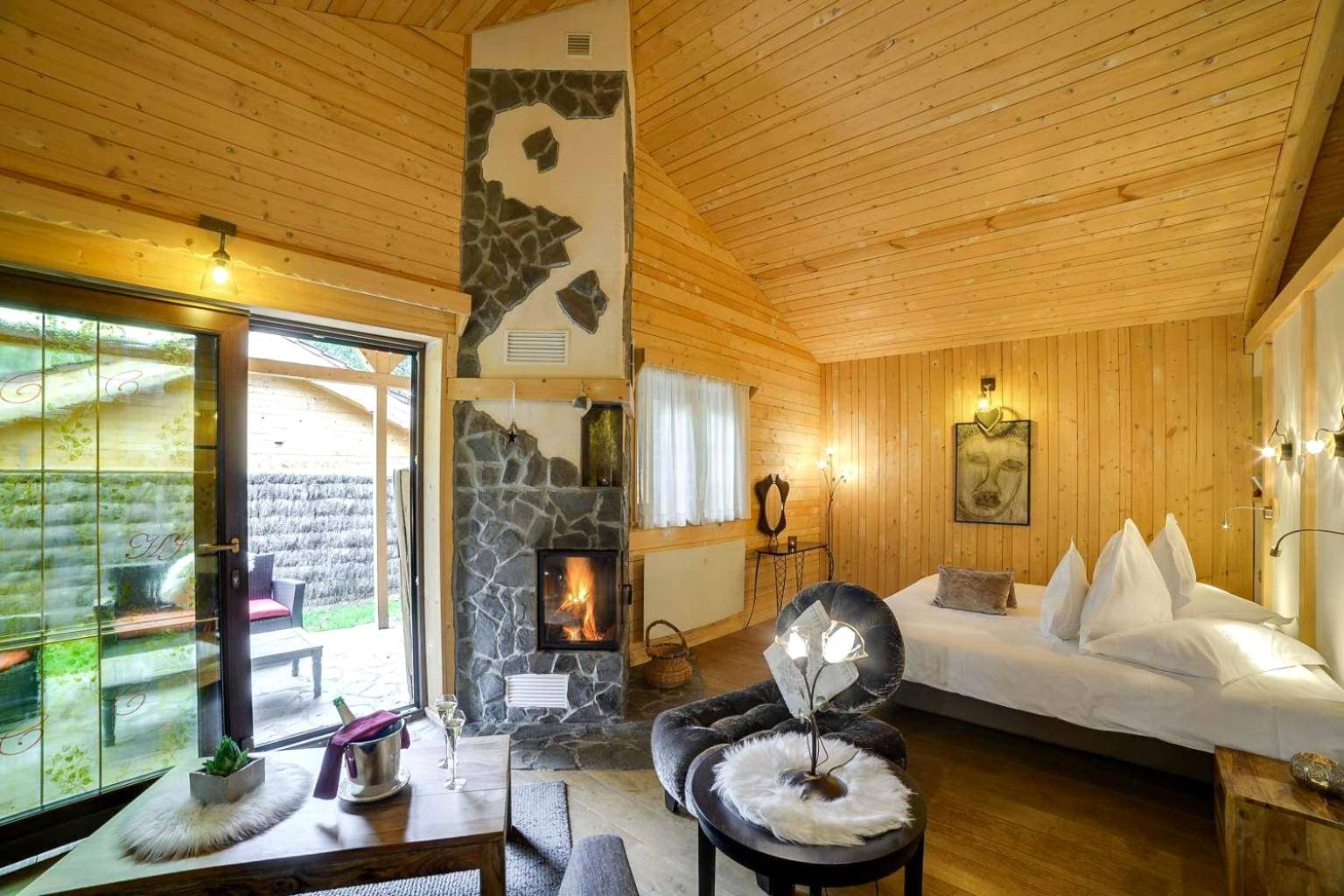 Salon chaleureux avec cheminée en pierre - Domaine du Haut Jardin Hôtel & Chalets Spa Privé