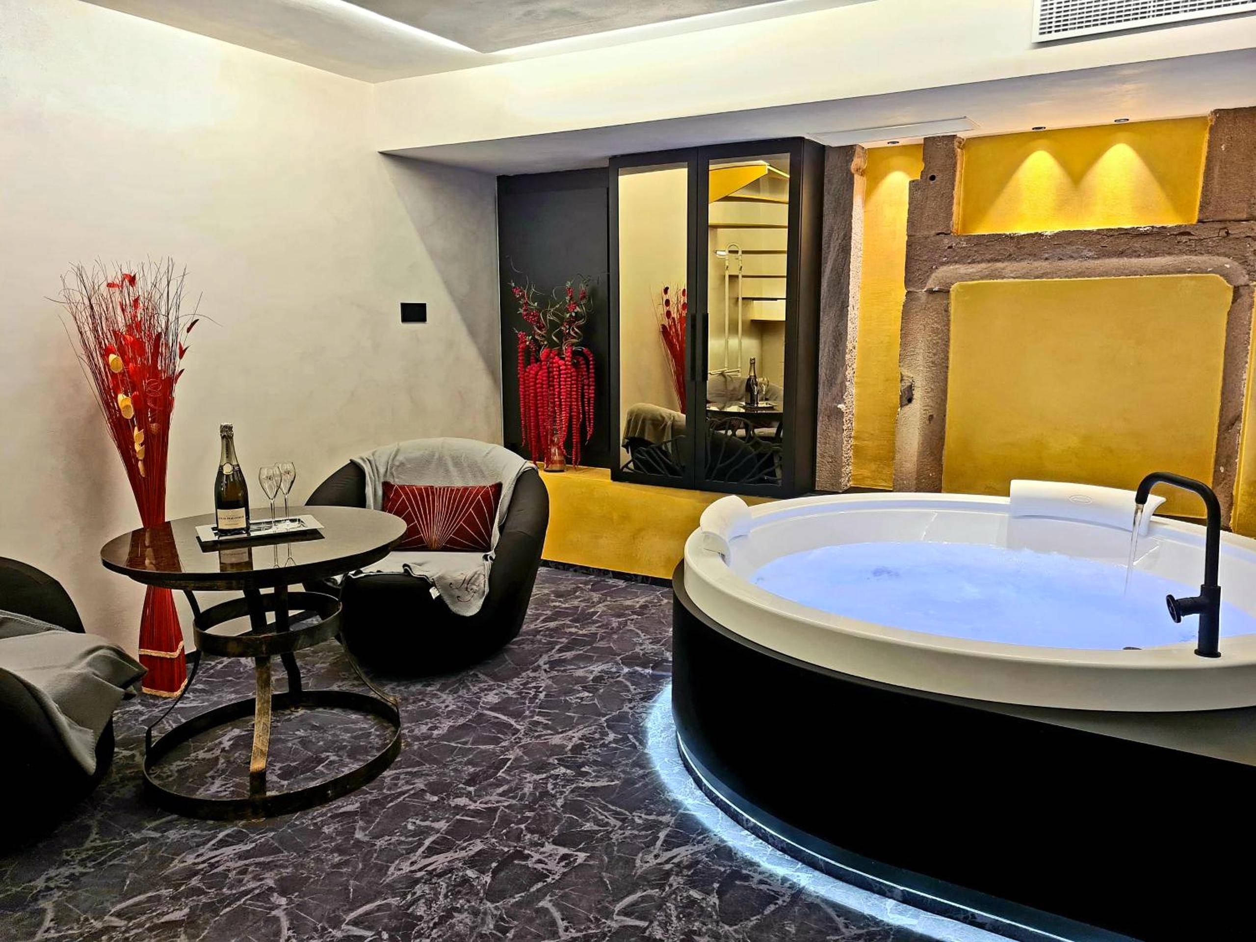 Baignoire balnéo ronde et coin salon moderne - Domaine du Haut Jardin Hôtel & Chalets Spa Privé