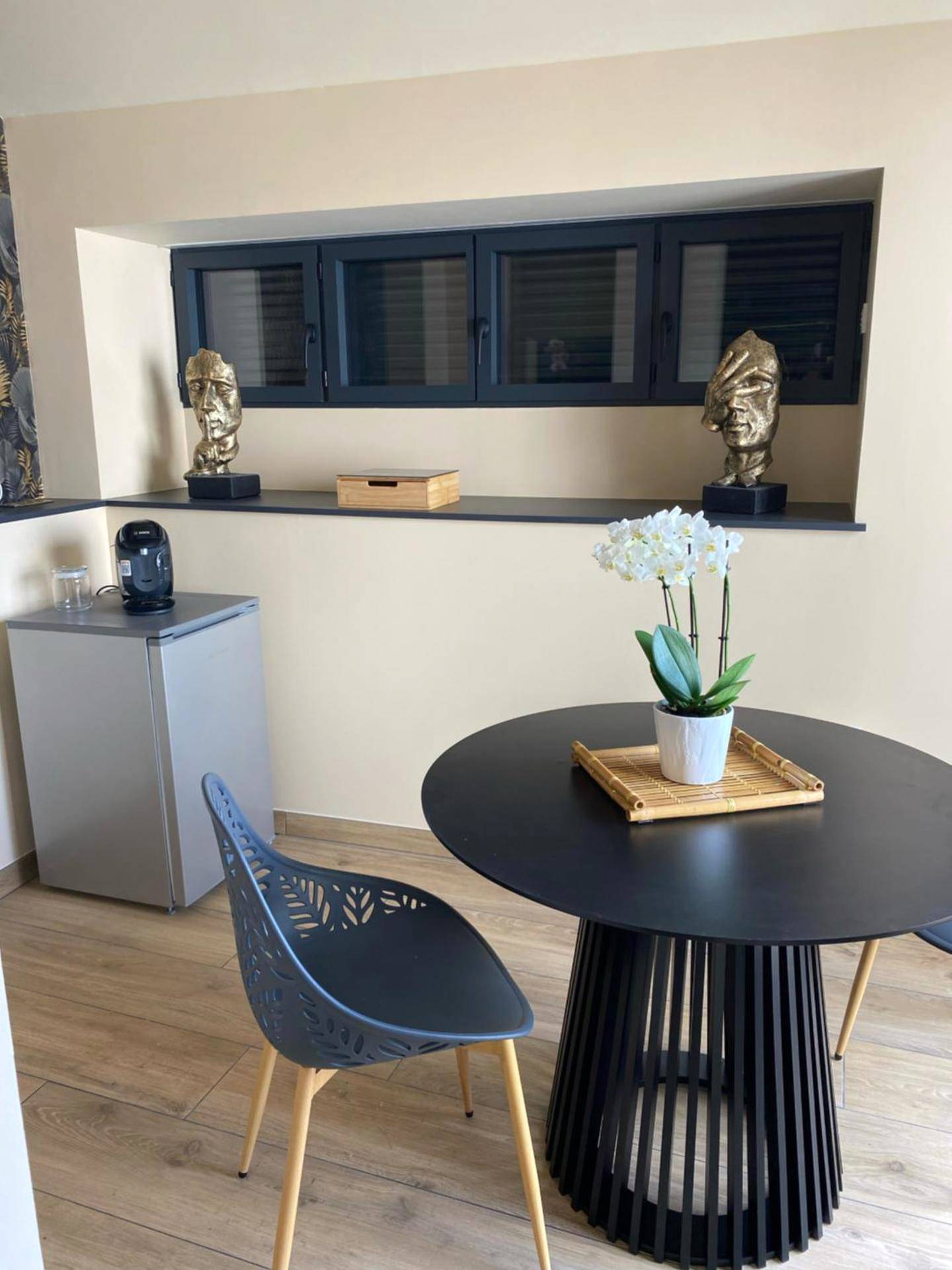 Espace repas avec table ronde et orchidée - Domaine du Saugé