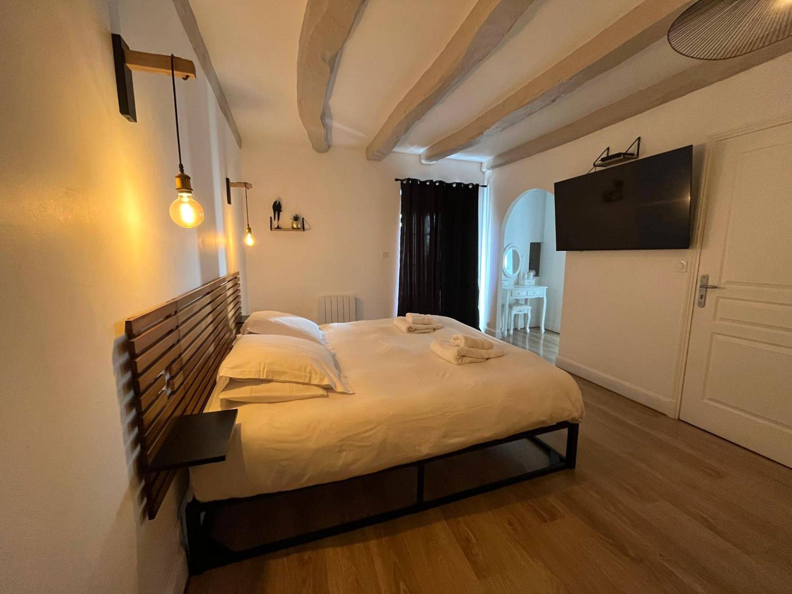 Chambre avec lit king size et poutres apparentes - Le Domaine des Songes