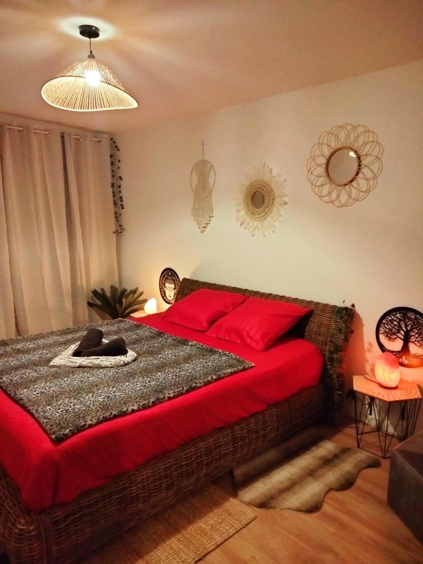 Lit double avec parure rouge et décoration bohème - Maison Prestige Le Donjon des Plaisirs Jacuzzi