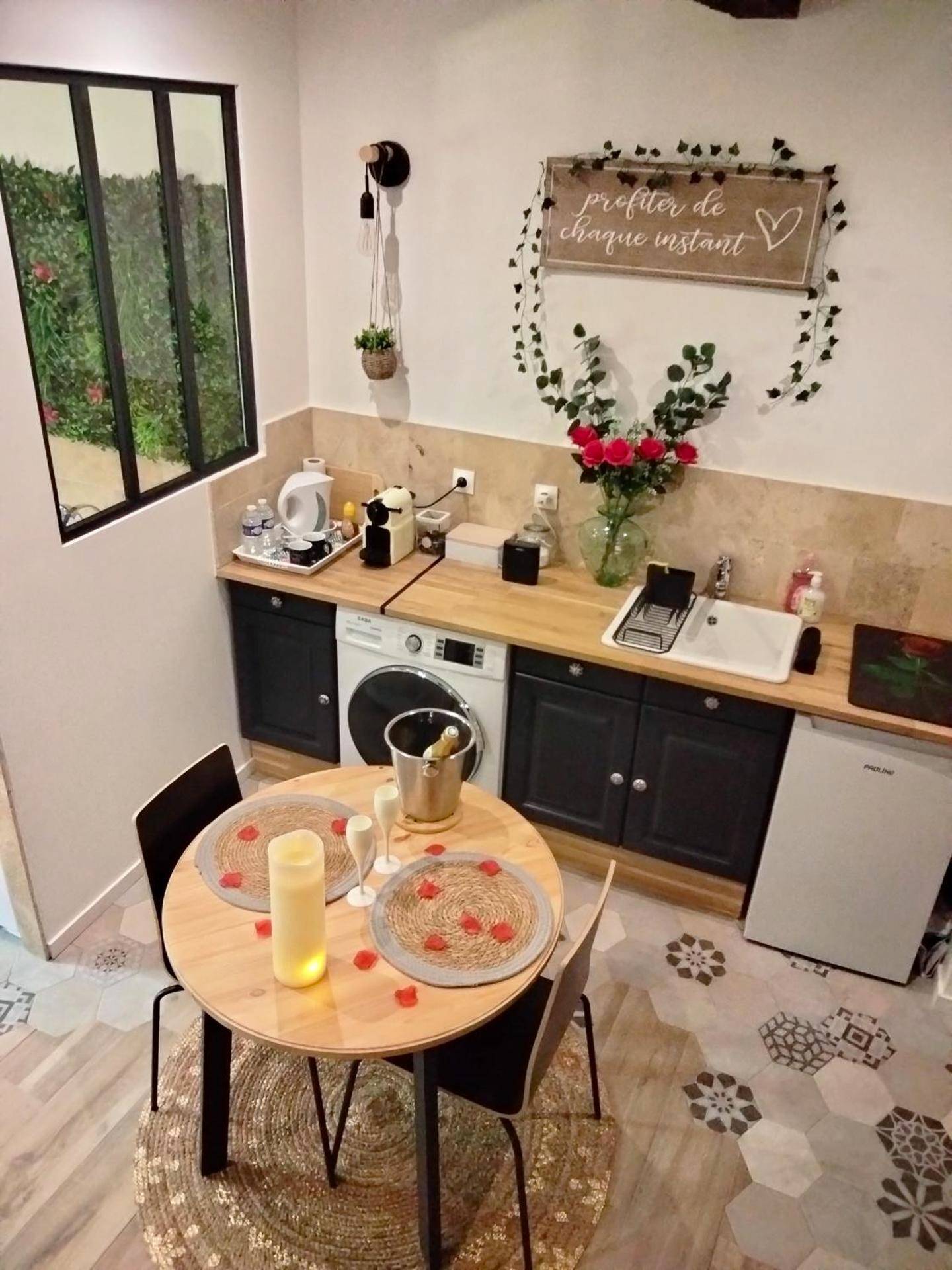 Espace cuisine et table avec pétales de rose - Maison Prestige Le Donjon des Plaisirs Jacuzzi