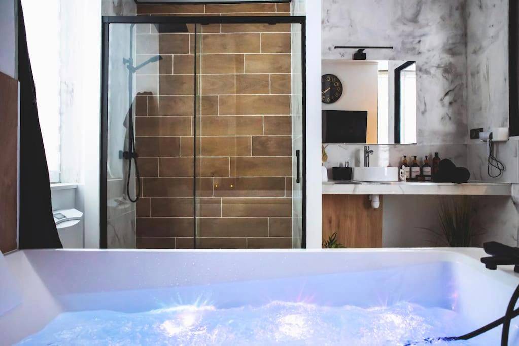 Jacuzzi avec éclairage bleu et douche à l'italienne - LOVE ROOM, La Douce Angevine