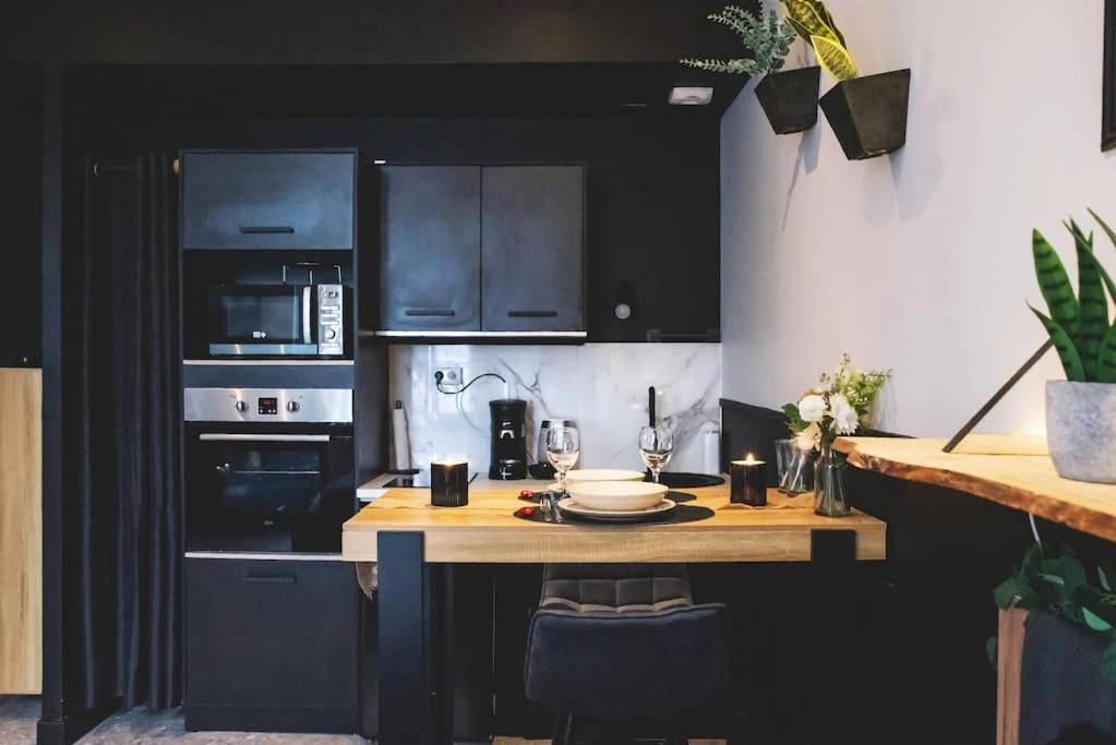 Cuisine équipée noire et table haute dressée - LOVE ROOM, La Douce Angevine