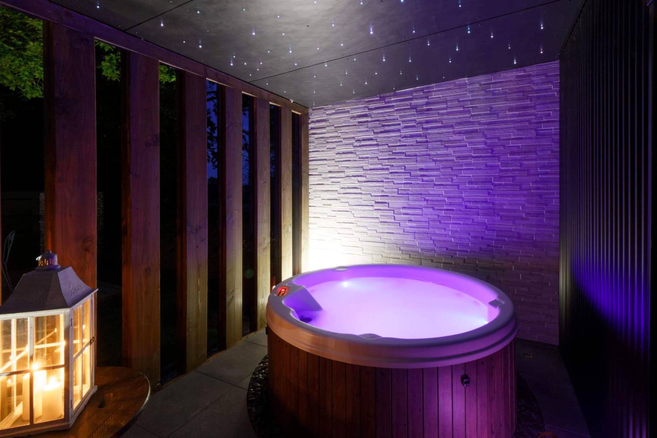 Jacuzzi privatif avec éclairage violet et ciel étoilé - Love Room Sizun - La Douce Escapade