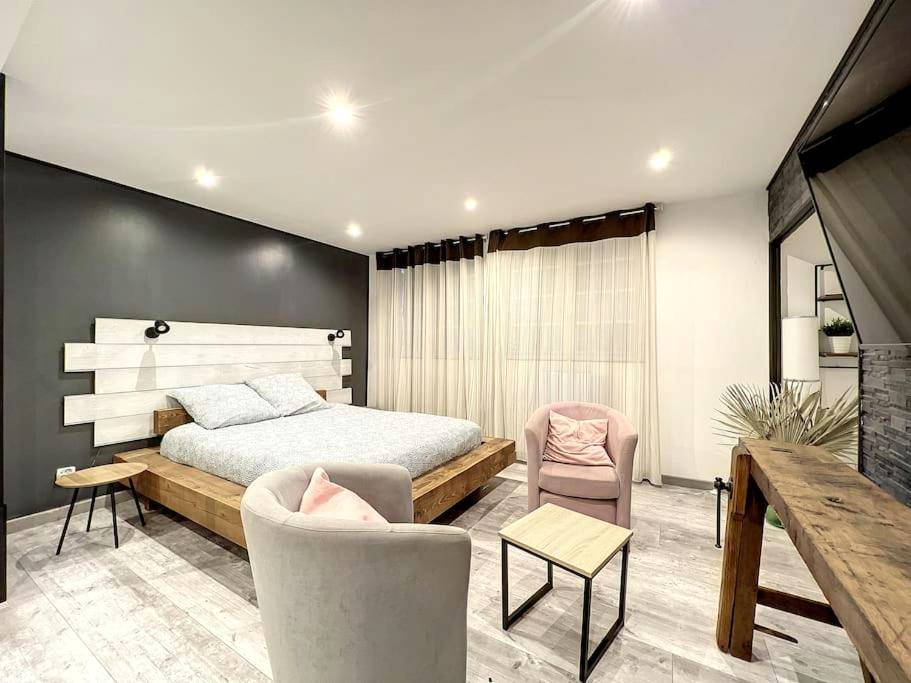 Lit double sur estrade en bois et fauteuils - Dream Loft jacuzzi - sauna