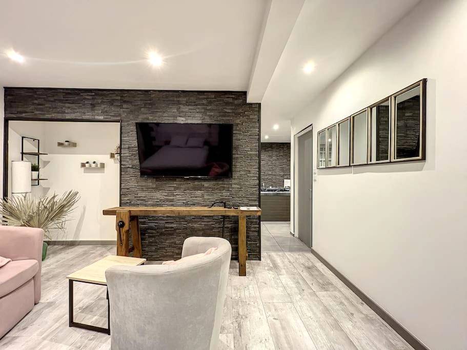 Salon avec télévision murale et mur en parement - Dream Loft jacuzzi - sauna
