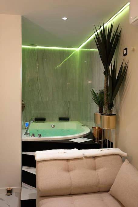 Baignoire balnéo d'angle et éclairage néon vert - Love room Dubaï & Balnéo