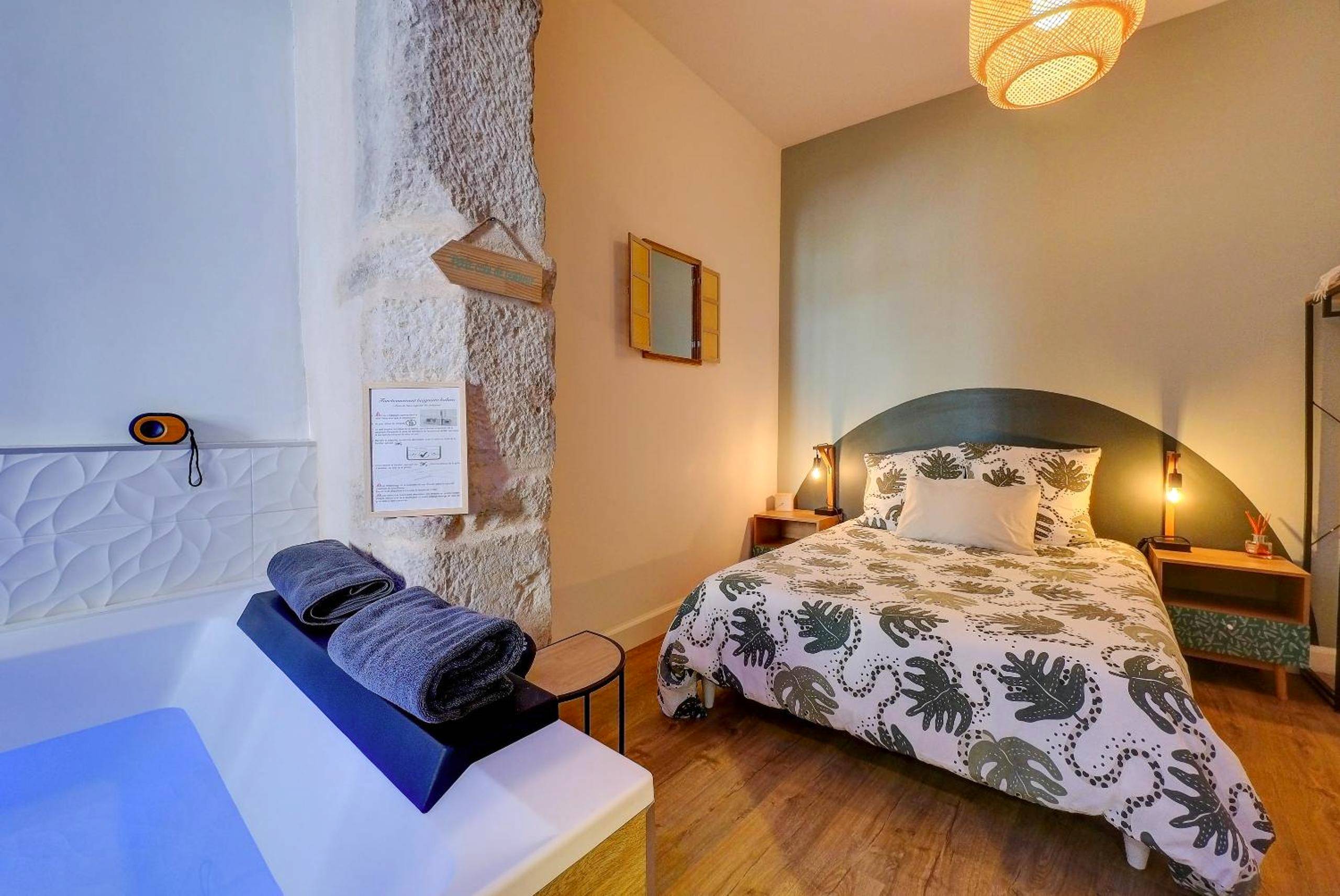 Chambre avec lit double et mur en pierre - Le Duché - Séjour romantique avec balnéo privative - Dijon centre