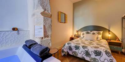 Chambre avec lit double et mur en pierre - Le Duché - Séjour romantique avec balnéo privative - Dijon centre