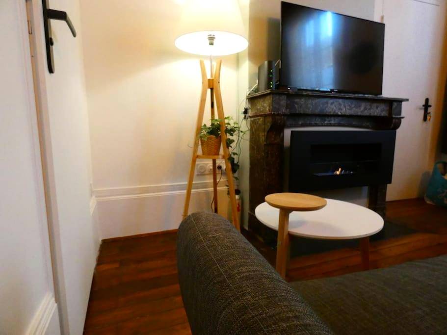 Espace détente avec cheminée et télévision - Le Duché - Séjour romantique avec balnéo privative - Dijon centre