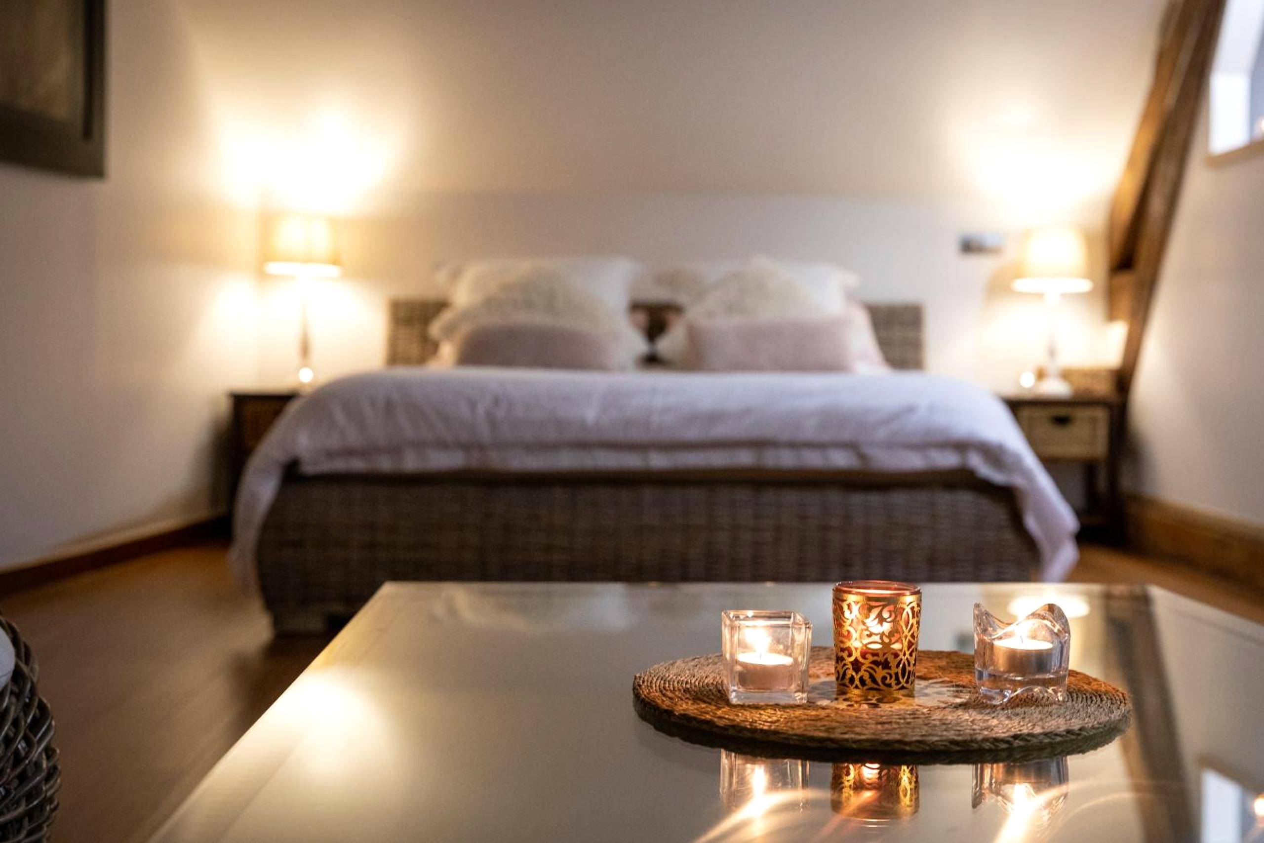 Chambre avec lit double et bougies au premier plan - Duo Détente