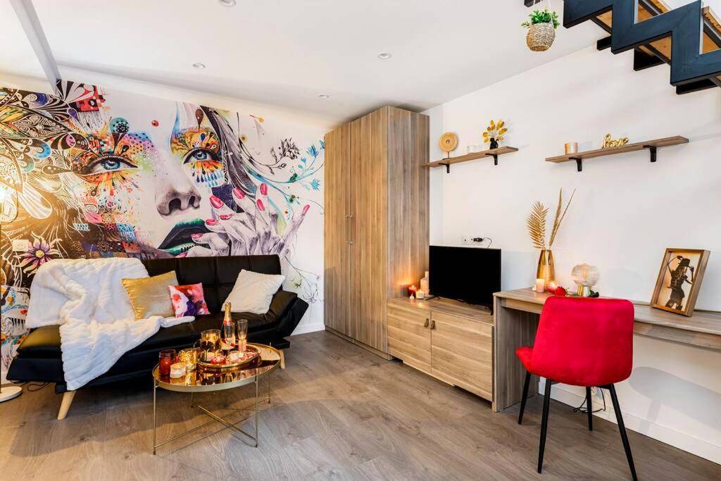 Salon avec fresque murale et canapé noir - Love Room Bourgoin - Jallieu - Duplex coup de coeur