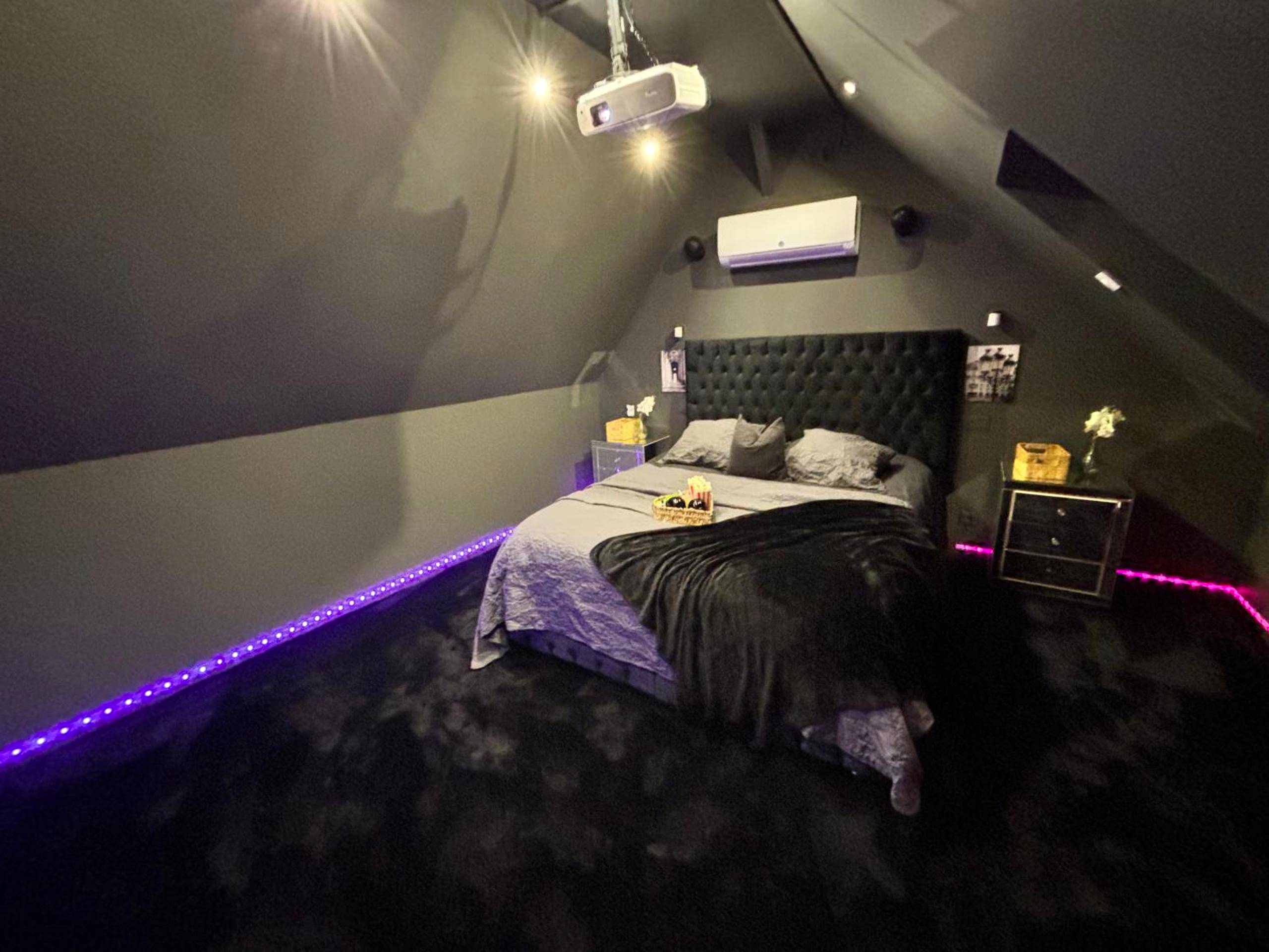 Chambre avec projecteur et ruban LED violet - Magnifique Duplex avec Jaccuzi, Sauna et Cinema Room Privatif