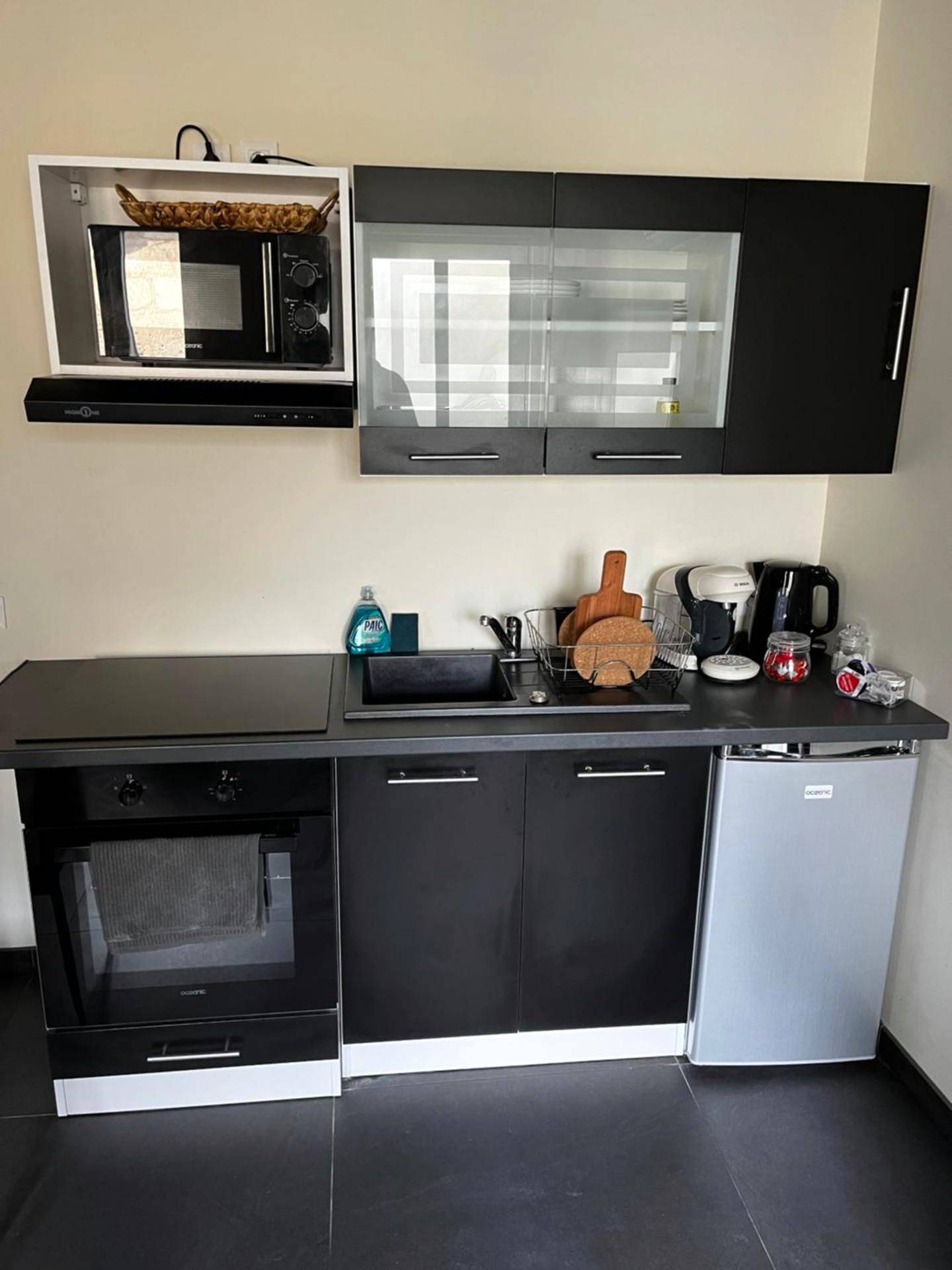 Kitchenette équipée noire et blanche - Magnifique Duplex avec Jaccuzi, Sauna et Cinema Room Privatif