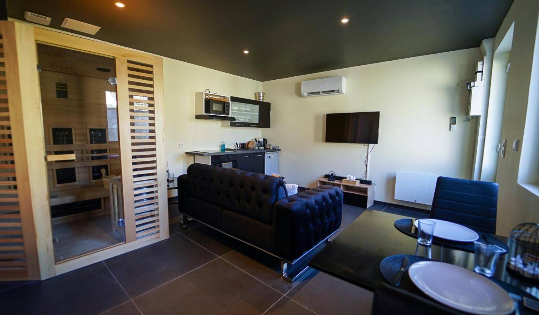 Espace salon avec sauna et coin repas - Magnifique Duplex avec Jaccuzi, Sauna et Cinema Room Privatif