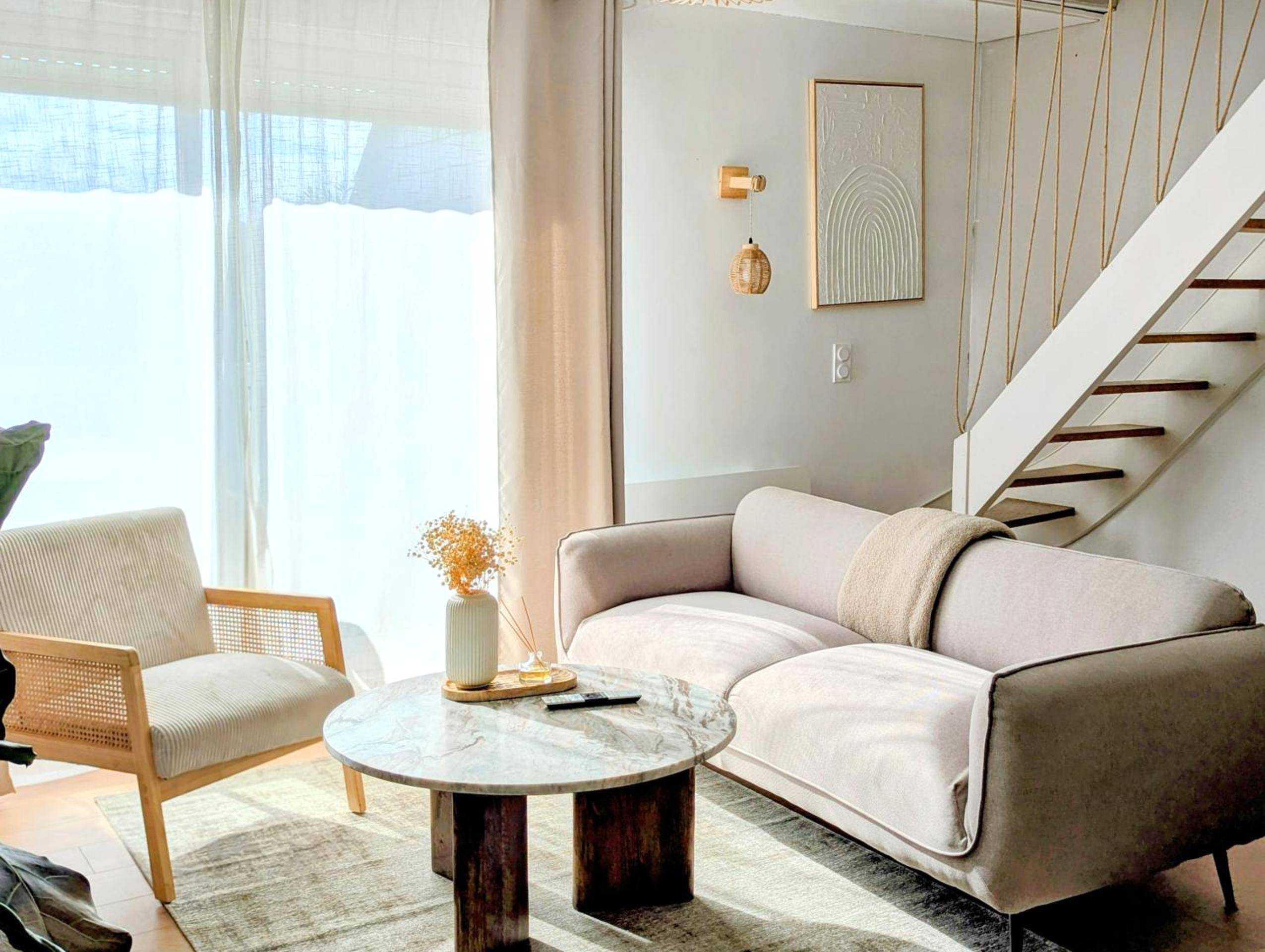 Salon lumineux avec canapé et table en marbre - Nid du Val - Duplex Lomy vue sur le port avec Sauna - balneo - 5mn plage