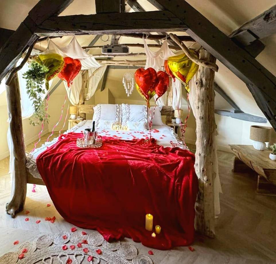 Lit à baldaquin en bois et ballons coeurs - Love Room Amiens - Duplex Safari jusqu'à 4 personnes, Spa, cinéma et lit...
