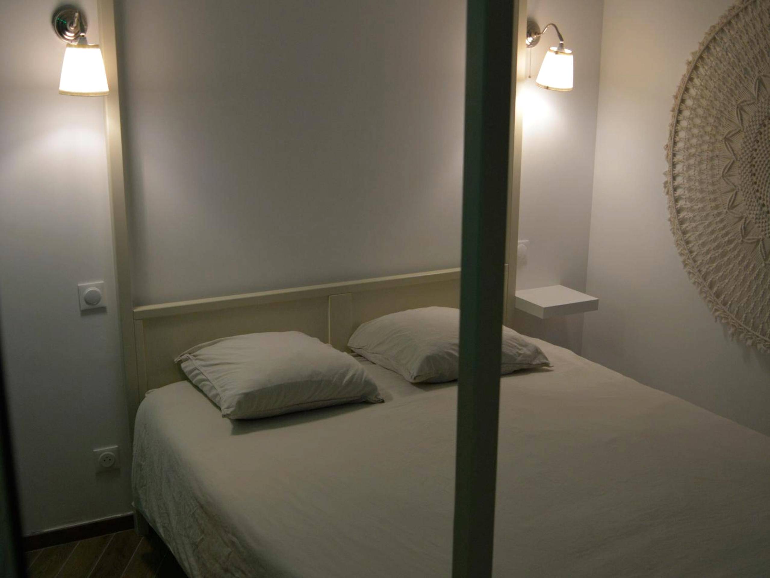 Lit double avec appliques et décoration murale - Eaux Spa