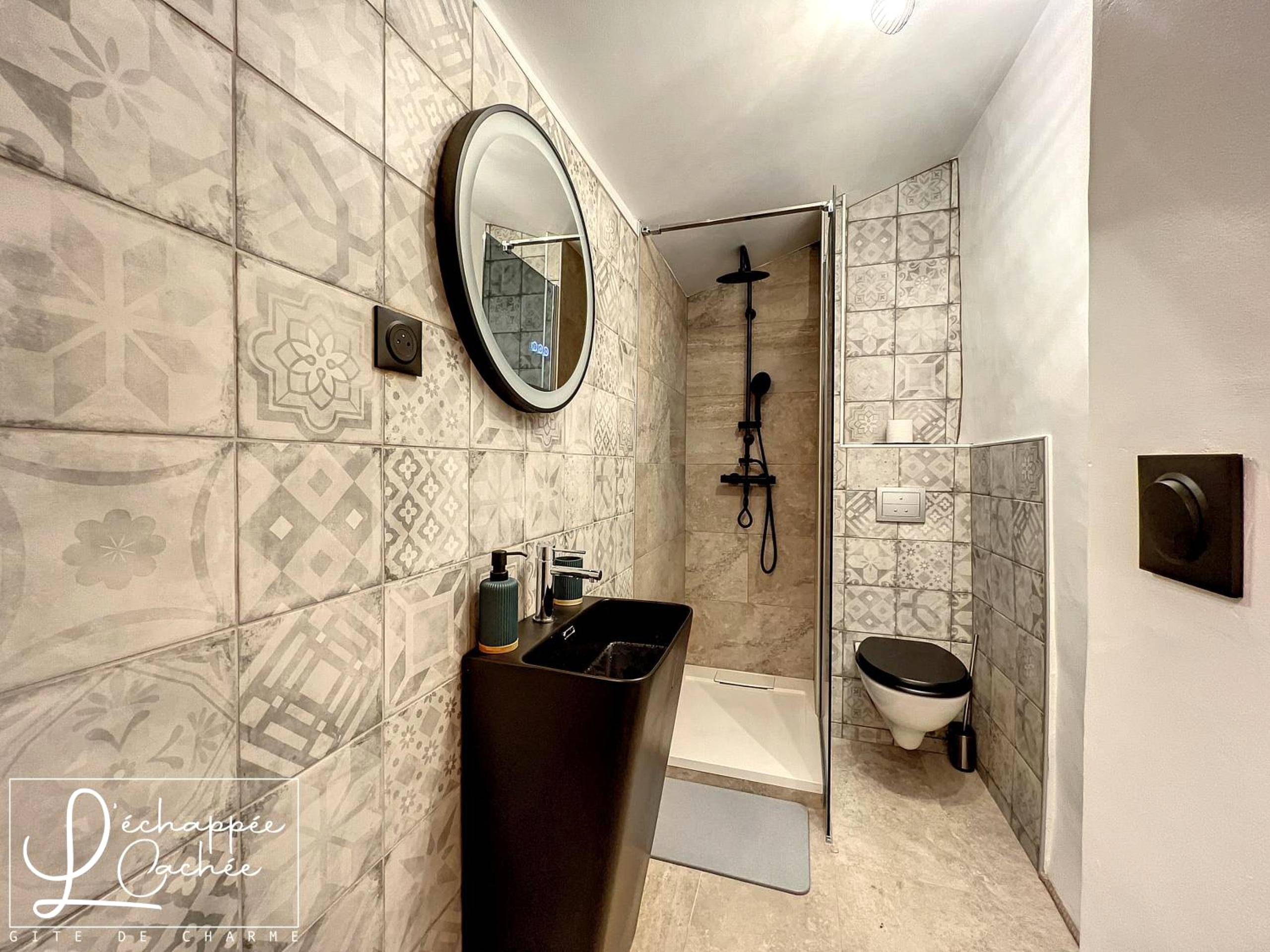 Salle d'eau moderne avec douche et vasque noire - L’ Échappée Cachée - Gîte de Charme