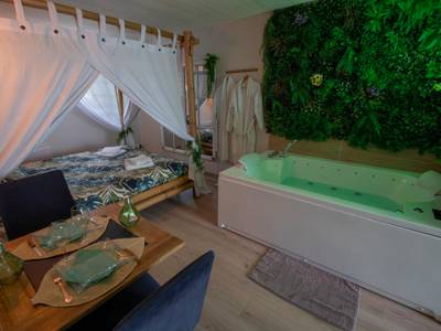 Jacuzzi et lit à baldaquin avec mur végétal - Love Room La Guérinière - L'échappée nocturne Nature et Zen