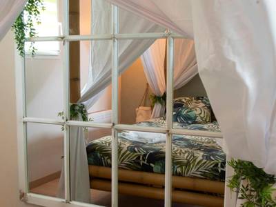 Miroir verrière reflétant le lit à baldaquin - L'échappée nocturne Nature et Zen