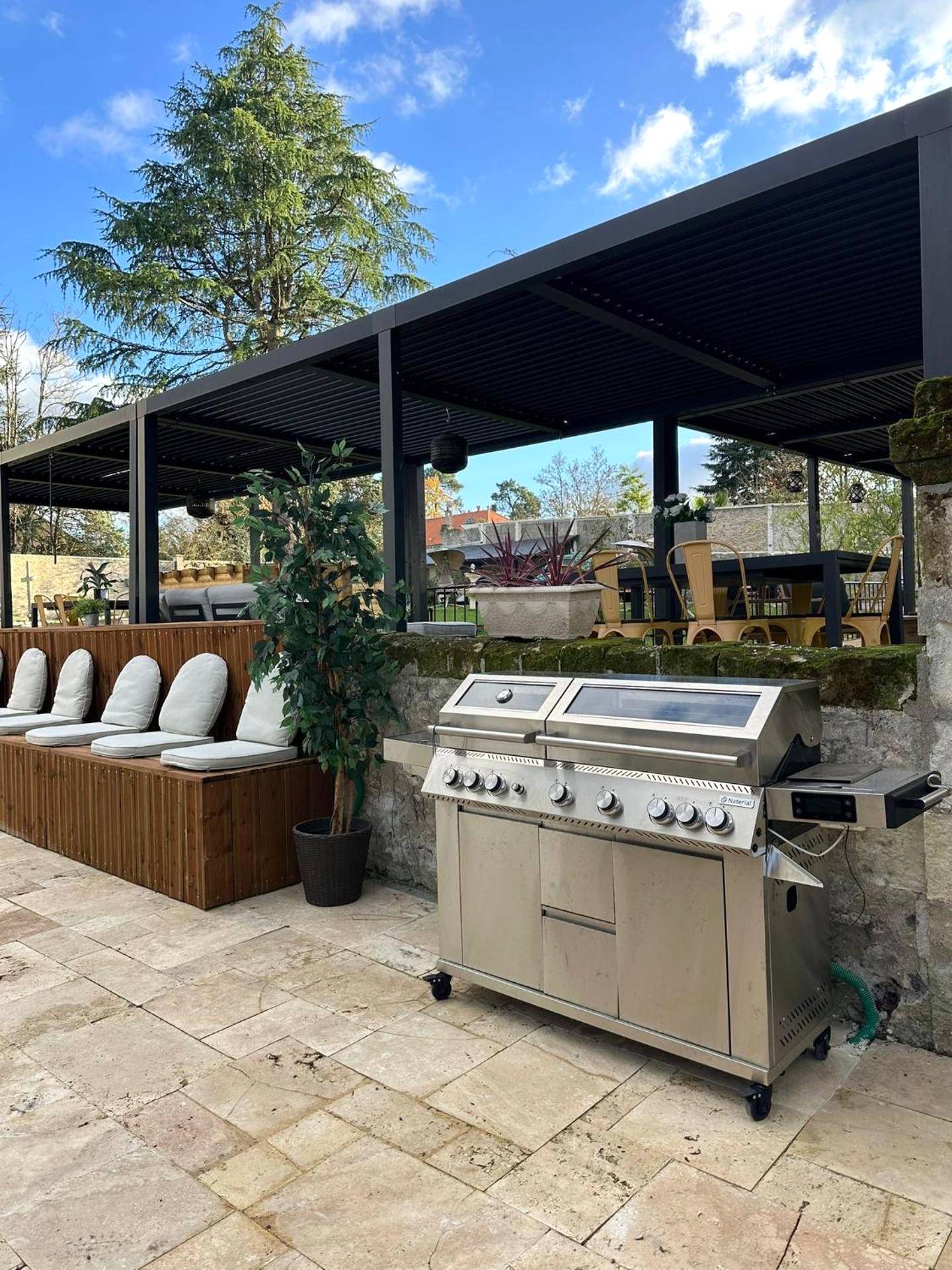 Terrasse extérieure avec grand barbecue inox - L'Écrin de l'Amour