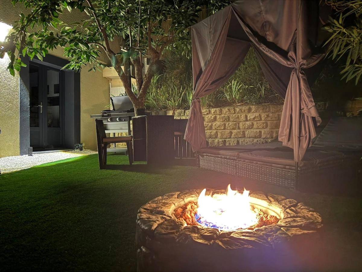 Brasero extérieur et lit de jardin sous baldaquin - Love Room L'ecrin d'Asteria