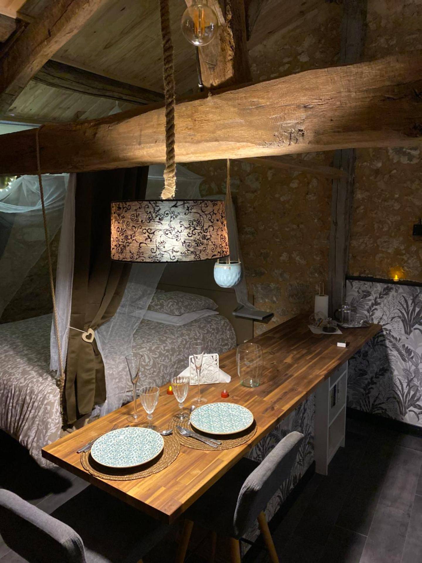 Table dressée pour deux et lit en arrière - plan - L'écrin Dasna