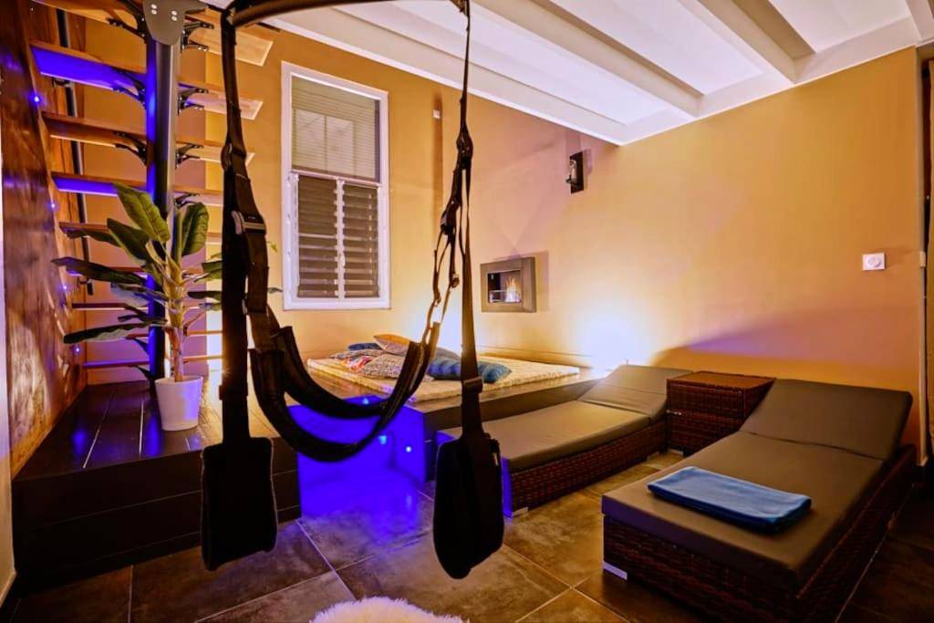 Espace lounge avec balançoire et lumière bleue - L'Eden d'Aphrodite