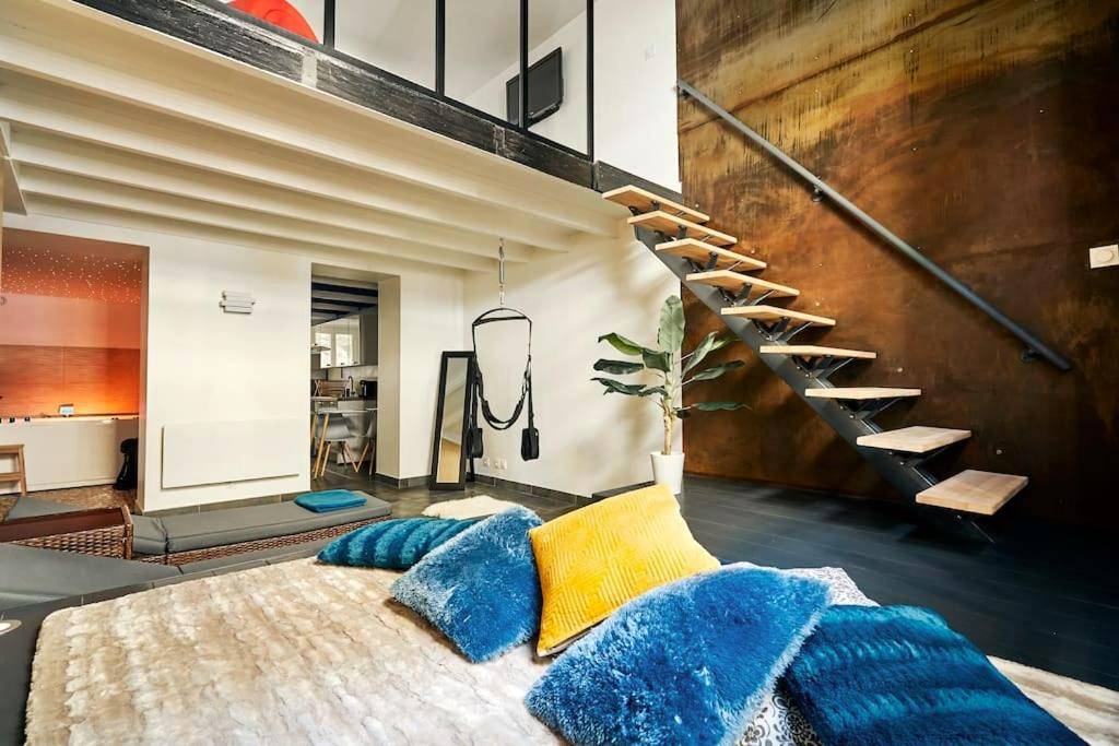 Lit avec coussins bleus et escalier design - L'Eden d'Aphrodite