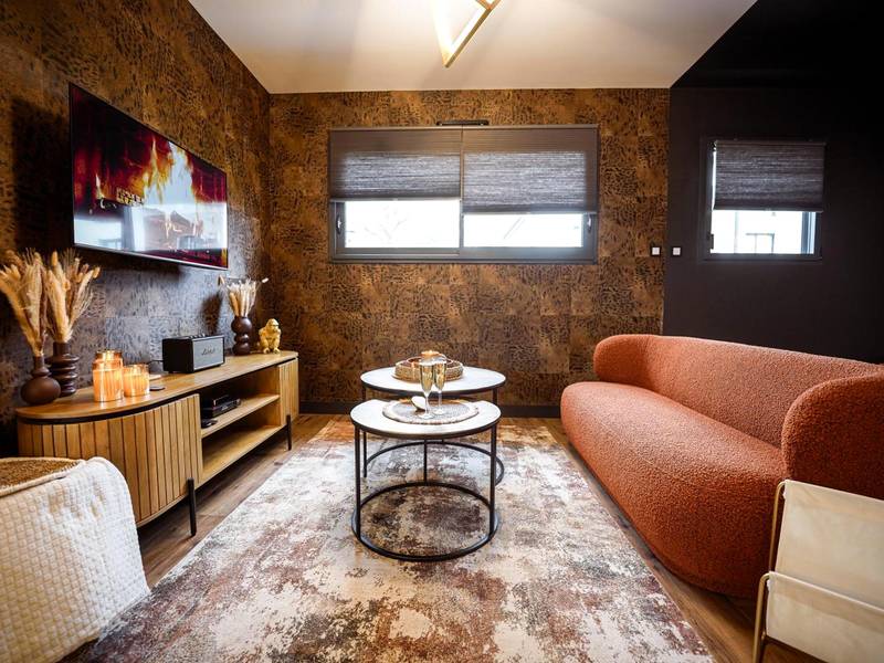 Coin salon avec canapé terracotta et télévision - * L’Eden * Maison romantique avec balnéo et sauna