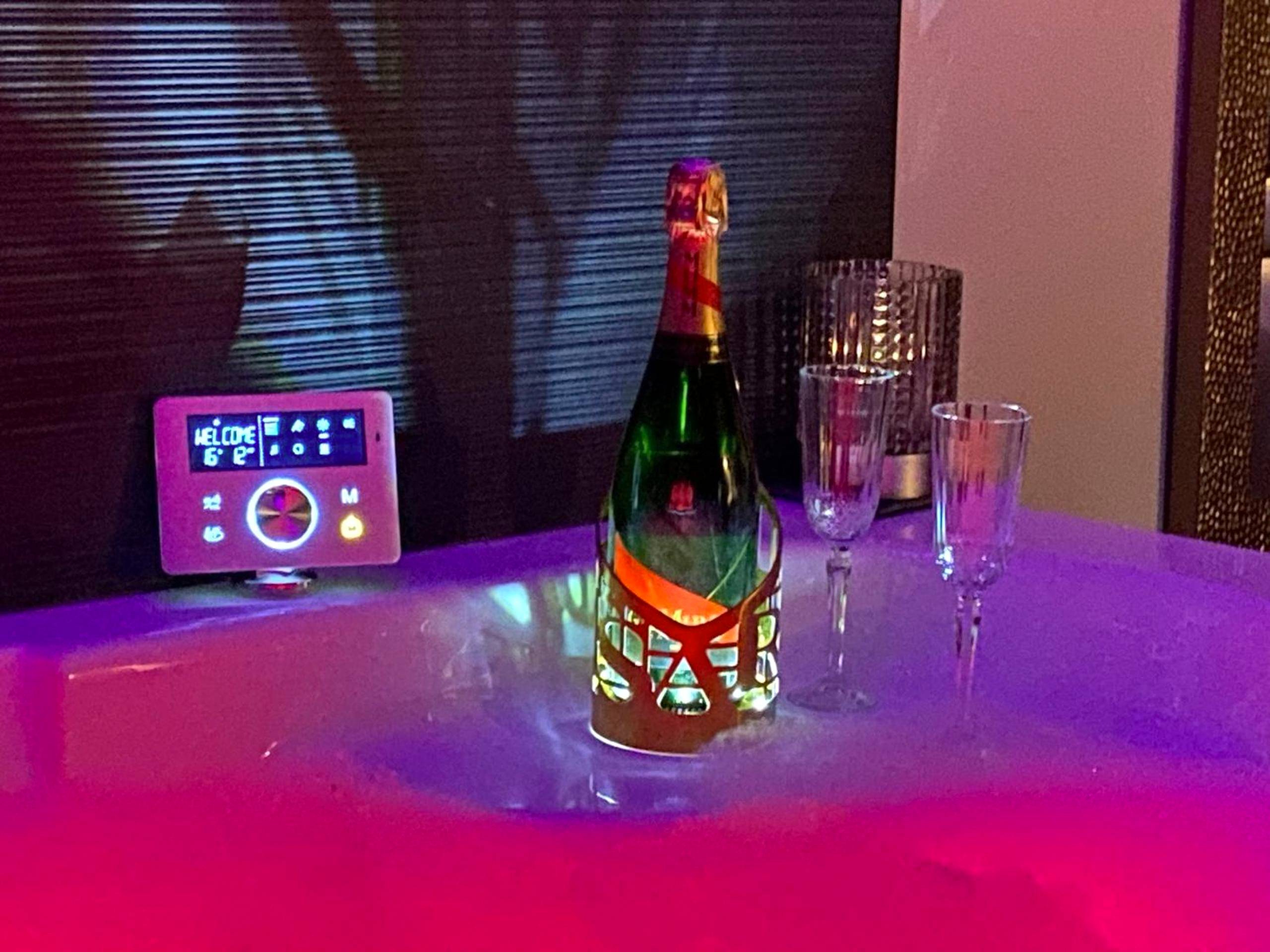Bouteille de champagne et flûtes au bord du spa - L'Eden