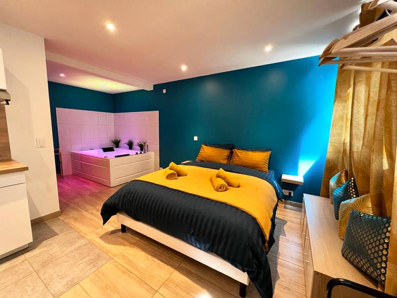 Lit double avec linge jaune et bleu - EDEN SUITE - Jacuzzi - Parking - Clim by Narbana