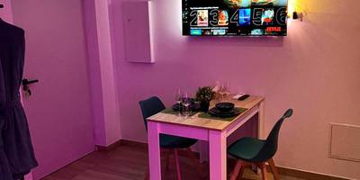 Coin repas avec table dressée et télévision - EDEN SUITE - Jacuzzi - Parking - Clim by Narbana