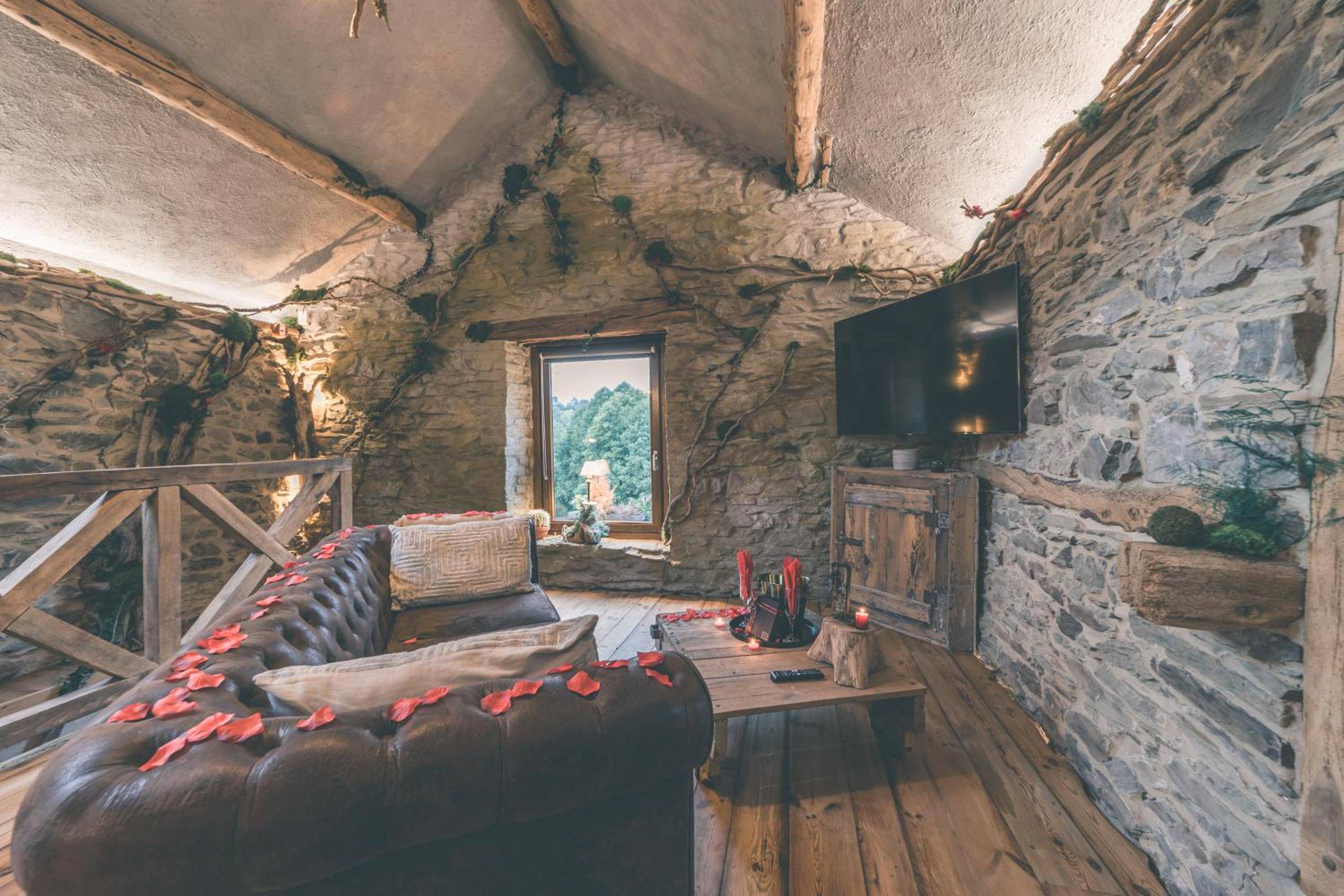 Salon avec canapé Chesterfield et murs en pierre - Romantic Getaway - Sauna and Jacuzzi - El Clandestino