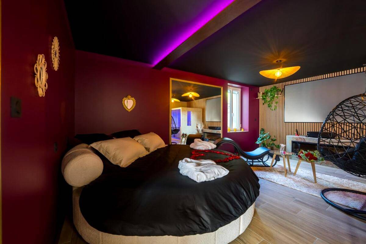 Lit rond noir avec pétales de rose rouges - Love Room Elixir du désir