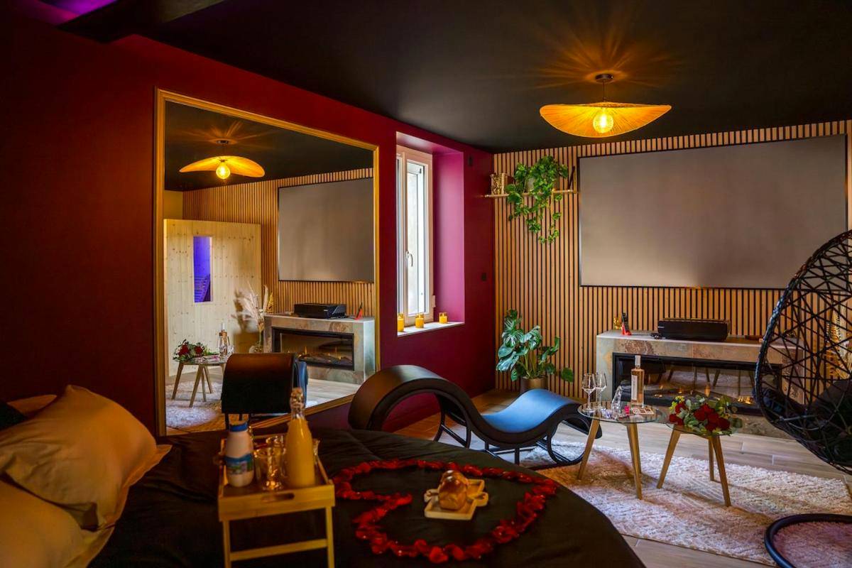 Espace salon avec écran géant et cheminée - Love Room Elixir du désir