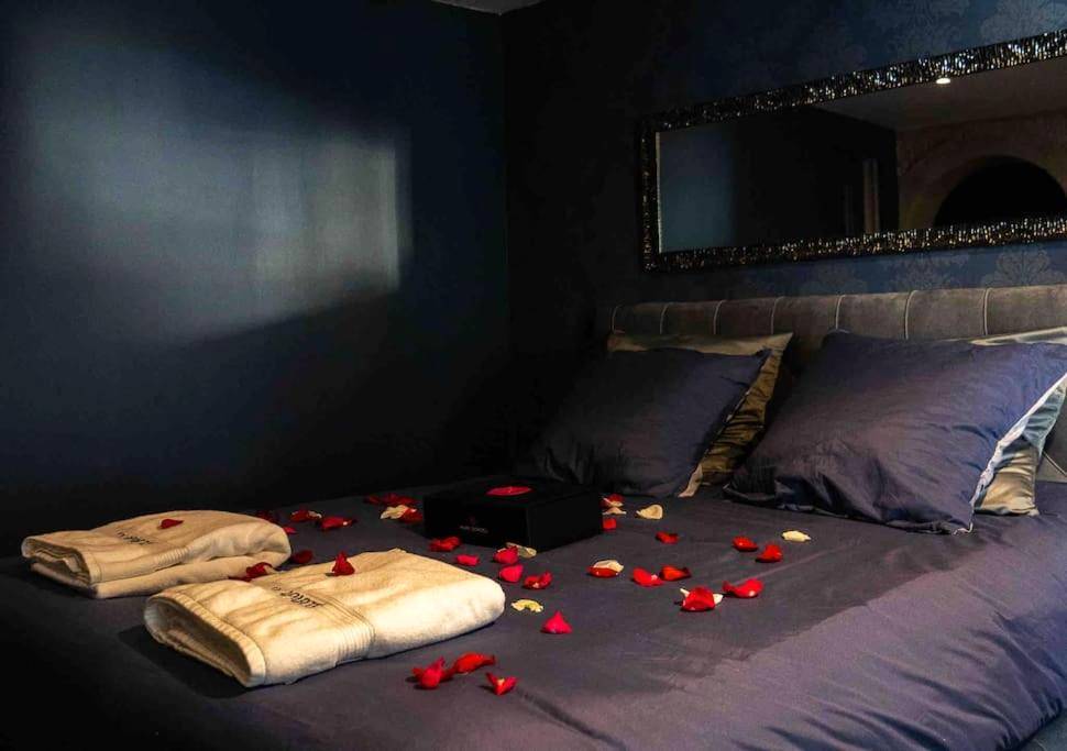 Lit double avec pétales de rose et serviettes - Love Room Caen - Loveroom En Aparté Caen