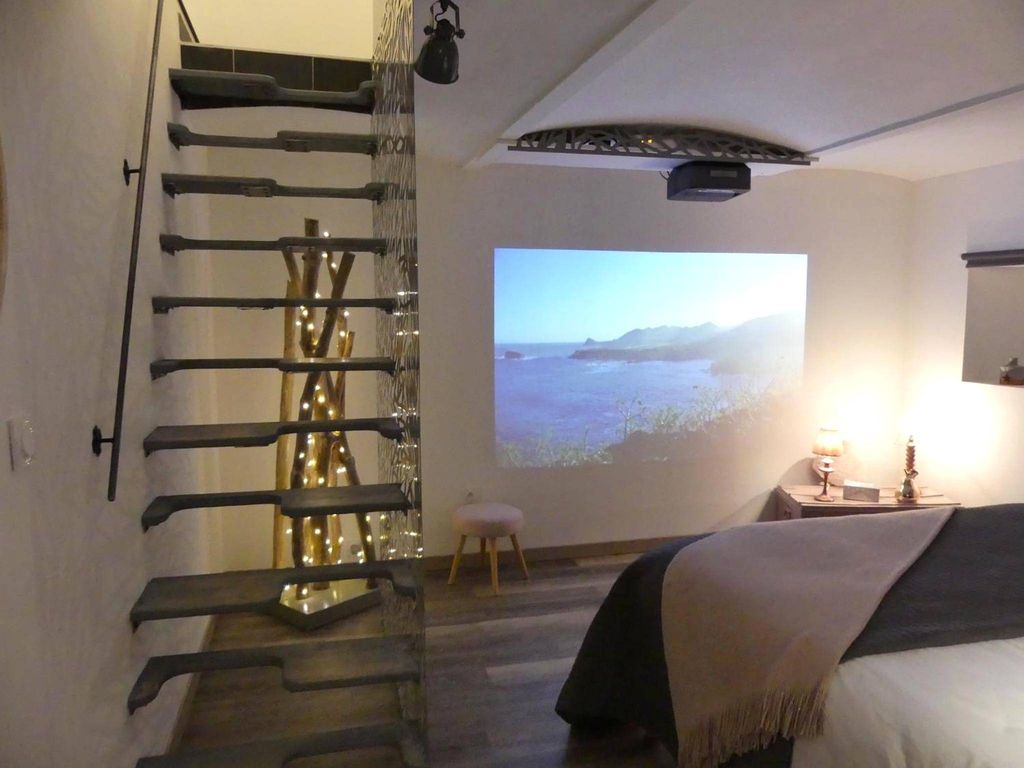 Vidéoprojecteur face au lit et escalier design - Entre Nous - La Poste