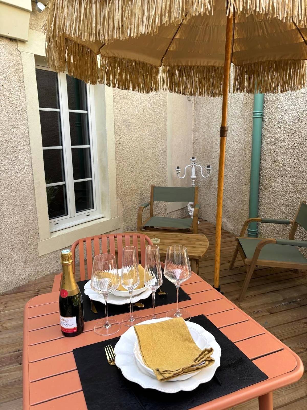 Terrasse avec table dressée et parasol frangé - Love Room L'Entre Nous